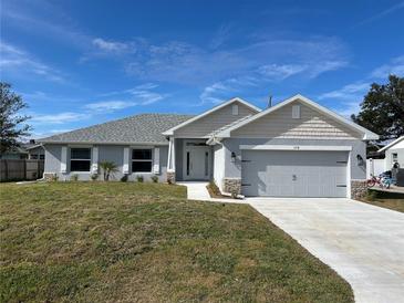 Newly constructed one-story home with gray siding, landscaping, and a two-car garage at 378 Rallus Rd, Venice, FL 34293