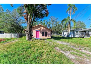 Tan house with pink door and large tree in front yard at 5120 17Th Street E Ct, Bradenton, FL 34203