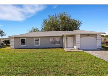 Newly constructed single-story home with a two-car garage and a spacious lawn at 6415 Coliseum Blvd, Port Charlotte, FL 33981