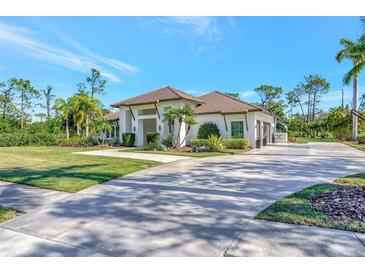 Single-story home with tile roof, driveway, and lush landscaping at 7003 River Club Blvd, Bradenton, FL 34202