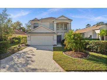Two-story house with a light gray exterior, a brick driveway, and palm trees at 11216 Coralbean Dr, Lakewood Ranch, FL 34202