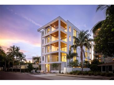 Modern white building with balconies and palm trees, showcasing luxurious design at 509 Golden Gate Pt # 3, Sarasota, FL 34236