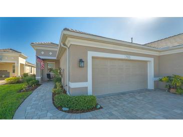 Home exterior featuring a two-car garage and walkway at 7525 Alumni Trl, Sarasota, FL 34243