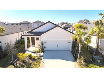 Single-story home with a two-car garage and landscaped front yard at 15213 Shady Palms Ln, Nokomis, FL 34275