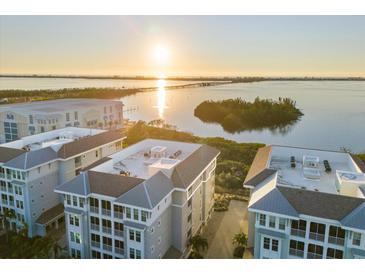 Aerial view of waterfront community with upscale building and sunset at 392 Aruba Cir # 403, Bradenton, FL 34209