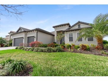 Beautiful single-story home featuring a well-manicured lawn and tropical landscaping at 4906 Lighthouse Bay Ln, Bradenton, FL 34211