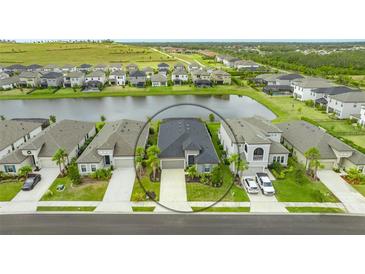 Aerial view of a home in a residential community with a pond at 6366 Grandview Hill Ct, Bradenton, FL 34203