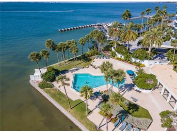 Aerial view of waterfront property with pool, lush landscaping, and boat slips at 888 Boulevard Of The Arts # 1705, Sarasota, FL 34236