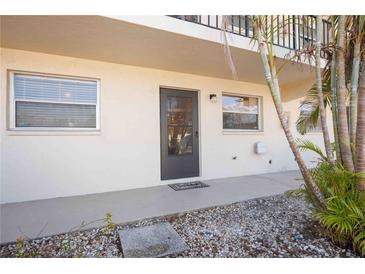 Exterior view of condo building showcasing a private entrance with landscaping at 2300 Stickney Point Rd Rd # 104, Sarasota, FL 34231