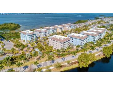 Aerial view of a waterfront community with multiple buildings, lush landscaping, and a scenic waterway at 396 Aruba Cir # 103, Bradenton, FL 34209