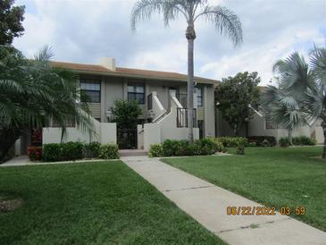 Attractive condo building with lush landscaping and walkway at 4470 Weybridge # 68, Sarasota, FL 34235