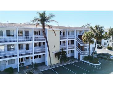 Two-story condo building with balconies, palm trees, and parking at 1582 Pleasant Rd # J35, Bradenton, FL 34207