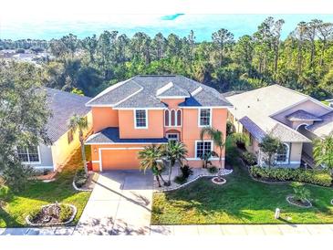 Two-story house with a gray roof and peach exterior, situated on a landscaped lot at 1800 Scarlett Ave, North Port, FL 34289