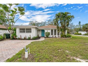 Charming single-story home with a well-maintained front yard, brick driveway, and a vibrant blue front door at 1097 Willis Ave, Sarasota, FL 34232