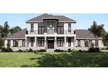 Two-story home with gray roof, white siding, stone accents, and a balcony at 32206 Grand National Drive, Myakka City, FL 34251