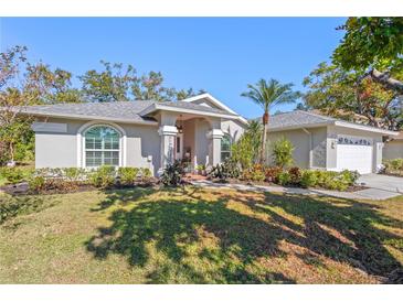 Single-story home with a gray exterior, lush landscaping, and a welcoming front porch at 5628 29Th Street E Cir, Bradenton, FL 34203