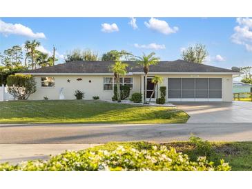 Single-story home with a two-car garage and well-manicured lawn at 20207 Gladstone Ave, Port Charlotte, FL 33952