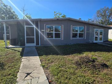 Newly renovated house exterior with gray siding and a walkway at 21459 Olean Blvd, Port Charlotte, FL 33952