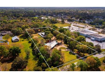 Aerial view of a single Gathering home on a large lot with mature trees at 3825 Sarasota Golf Club Blvd, Sarasota, FL 34240