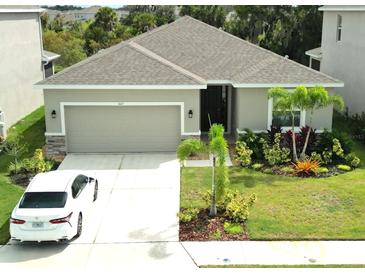 Single-story house with a two-car garage and landscaped front yard at 4109 Quiet Rain Ct, Palmetto, FL 34221