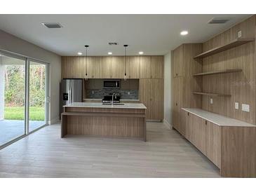 Open concept kitchen with island and stainless steel appliances at 5274 Neon Ave, North Port, FL 34291