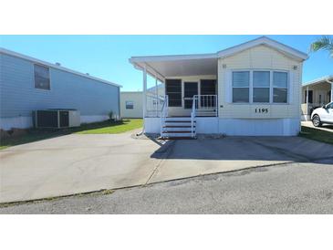 Front view of a yellow single-wide manufactured home with a carport and landscaping at 3333 26Th E Ave # 1195, Bradenton, FL 34208
