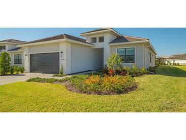 Single-story home with gray garage door, landscaping, and paved driveway at 5066 Fairhope Cir, Bradenton, FL 34211