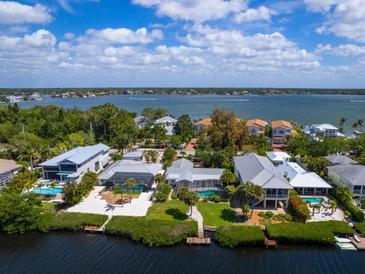 Aerial view of waterfront homes with private docks and lush landscaping at 7916 Midnight Pass Rd, Sarasota, FL 34242