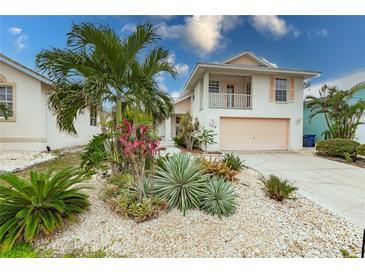 Charming two-story home featuring a balcony and lush tropical landscaping at 109 Tortuga Dr, Nokomis, FL 34275