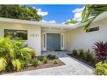 Modern home exterior with a blue front door and landscaped walkway at 1621 Pine Bay Dr, Sarasota, FL 34231