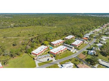 Aerial view of condo community with pool and lush landscaping at 209 Rubens Dr # F, Nokomis, FL 34275