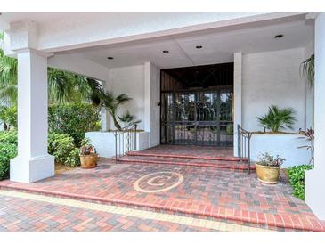 Inviting building entrance with brick pavers, lush landscaping, and a grand entrance at 4545 Gulf Of Mexico Dr # 408, Longboat Key, FL 34228