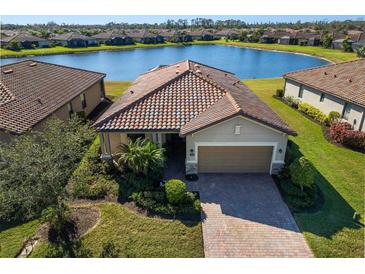 Single-Gathering home with tile roof, driveway, and landscaping; near a lake at 6517 Willowshire Way, Bradenton, FL 34212
