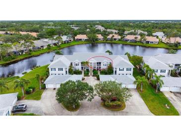 Two-story building near a lake with beautiful landscaping at 905 Addington Ct # 203, Venice, FL 34293
