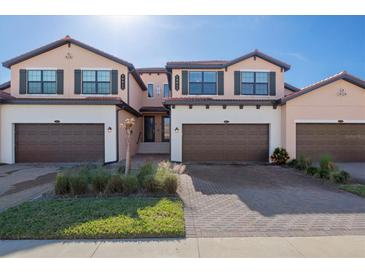 Three-story townhouses with brown garages and landscaped yards at 10817 Tarflower Dr # 202, Venice, FL 34293