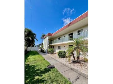 Exterior view of a condo building with well-maintained landscaping and walkway at 3504 Beneva Rd # 206, Sarasota, FL 34239