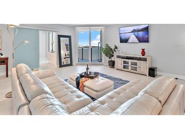 Spacious living room with sectional sofa, large TV, and water views at 4822 Ocean Blvd # 10E, Sarasota, FL 34242