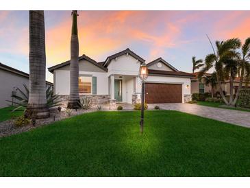 Inviting home exterior with landscaping and a two-car garage at 5727 Magnolia Ridge Pl, Sarasota, FL 34243