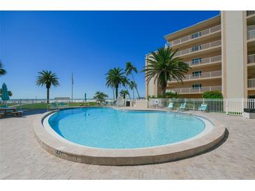 Inviting kidney-shaped pool with surrounding patio and lounge chairs at 5830 Midnight Pass Rd # 406, Sarasota, FL 34242