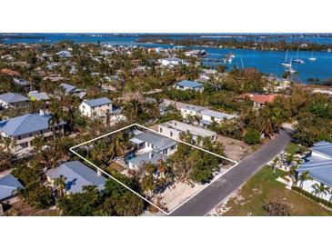 Aerial view of a single-Gathering home with a large backyard and surrounding neighborhood at 611 Hibiscus Way, Longboat Key, FL 34228