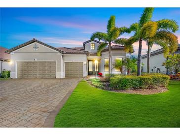 Two-story house with a three-car garage and palm trees in the front yard at 7125 Gradford Ct, Lakewood Ranch, FL 34202