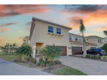 Exterior of a beautiful two-story townhome with a two-car garage and landscaped yard at 7835 Hidden Creek Loop # 101, Lakewood Ranch, FL 34202