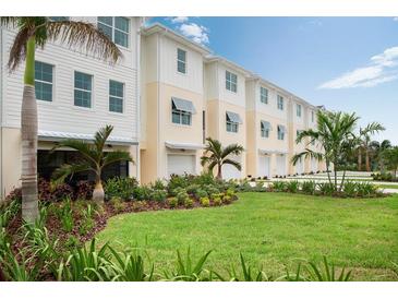 Row of modern townhouses with attached garages and landscaped lawn at 9981 Key Haven Rd, Seminole, FL 33777