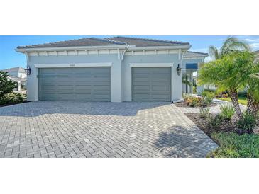 Two-car garage with herringbone driveway and landscaping at 10300 Lake George Ave, Sarasota, FL 34241