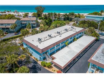 Coastal condo building featuring a covered parking area with beach access at 4307 Gulf Dr # 103, Holmes Beach, FL 34217