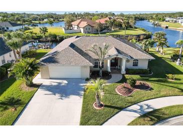 Single-story home with a large backyard, driveway, and canal views at 8661 Quinn Ct, North Port, FL 34287