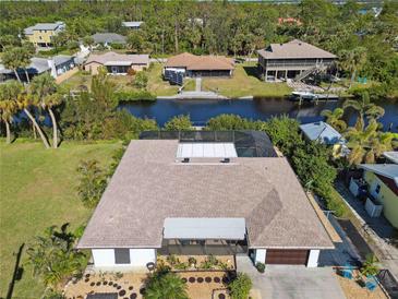 Aerial view of canal-front home with pool and lush landscaping at 9025 Hilolo Ln, Venice, FL 34293