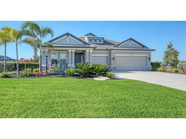 Gray house with two-car garage, landscaping, and a large front yard at 1825 Twin Rivers Trl, Parrish, FL 34219
