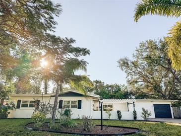 Charming white home with lush landscaping and a covered entryway at 214 Gaines Ave, Sarasota, FL 34243