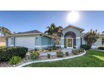 Light blue house with a two-car garage and landscaped yard at 42 Marker Rd, Rotonda West, FL 33947